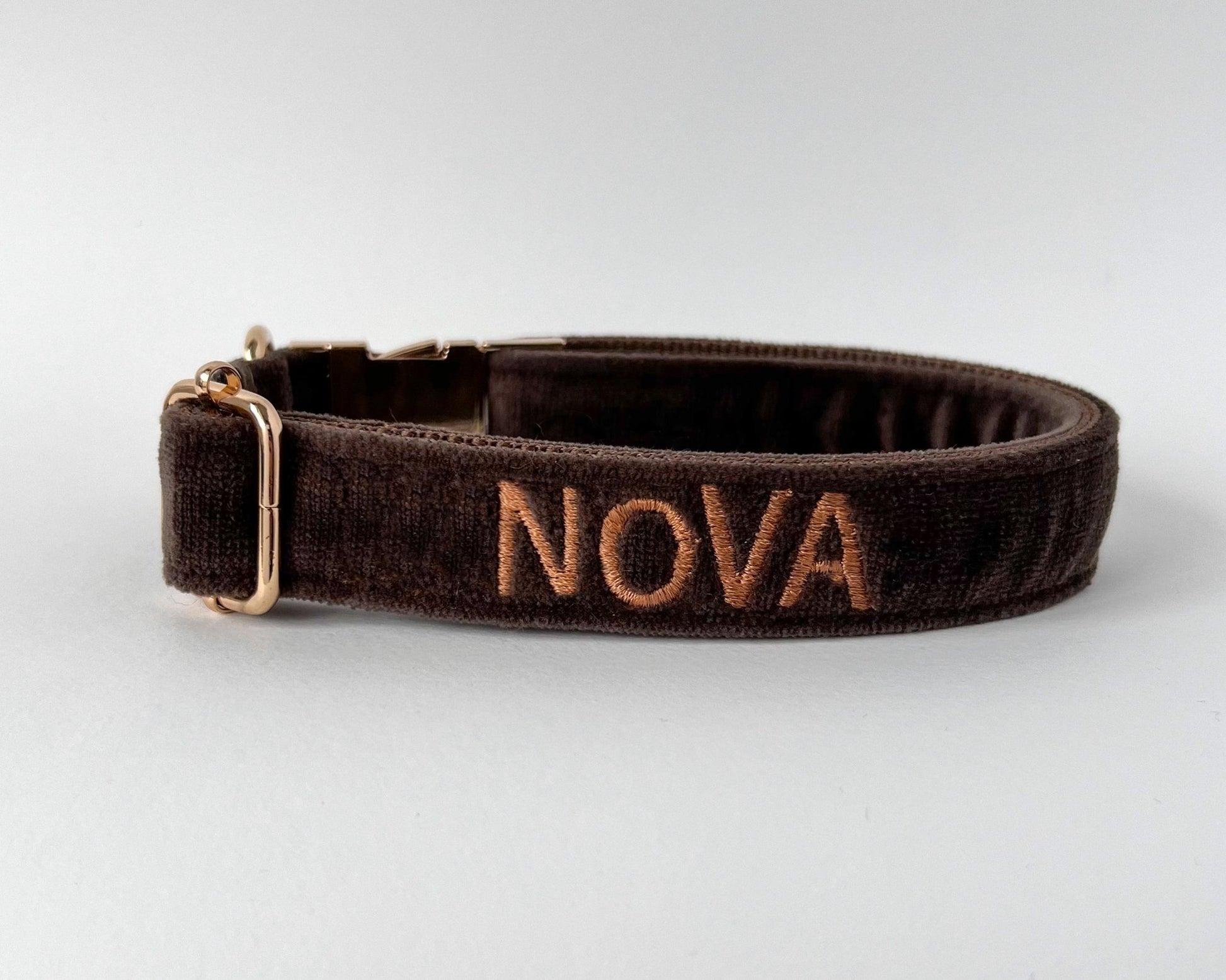 Personalized embroidery dog collars featuring the name NOVA on a brown fabric collar