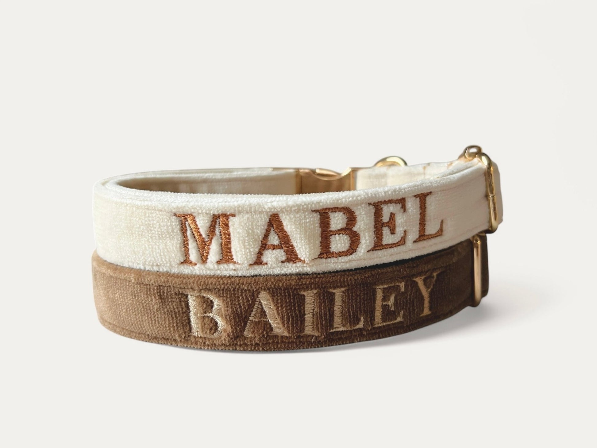 Personalized embroidery dog collars in cream and brown featuring names MABEL and BAILEY