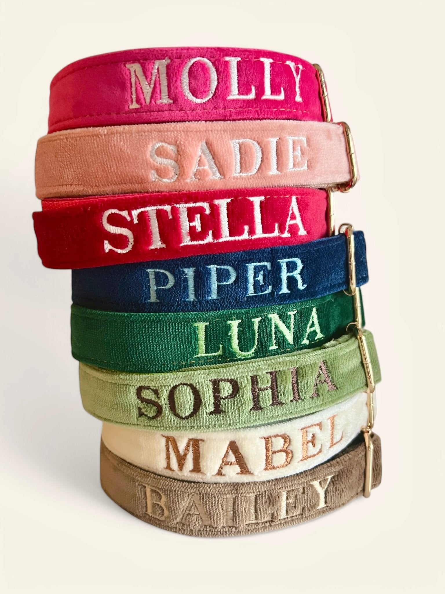 Colorful personalized embroidery dog collars stacked with names like Molly and Stella for stylish pets